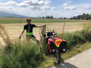 biker on the road infront of a field